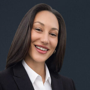 Smiling person in a black suit jacket.